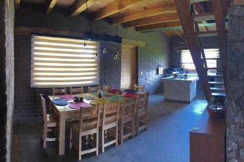 a dining room with a table and chairs and a kitchen at Cabaña Los Franceses in Tapalpa