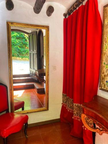 a room with a red curtain and a mirror at Casa con terraza con vistas al valle - Cal Taverner in Montsonis