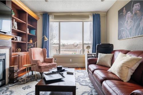 a living room with a leather couch and a window at Royal highland livingroom bedroom suite in Calgary