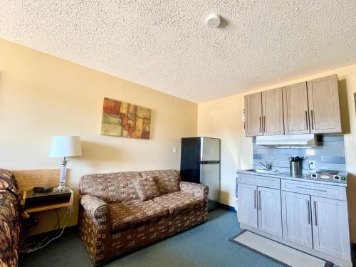a living room with a couch and a kitchen at Dockside Inn in Cold Lake