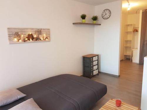 ein Schlafzimmer mit einem Bett und einer Uhr an der Wand in der Unterkunft Logement cosy, calme, vue mer, sud France in La Seyne-sur-Mer