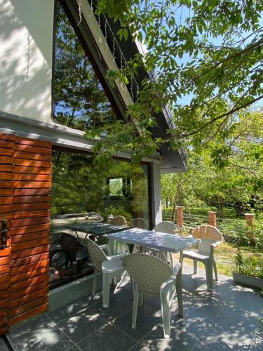 a patio with a table and chairs and a grill at Woodland Paradise in Gabala