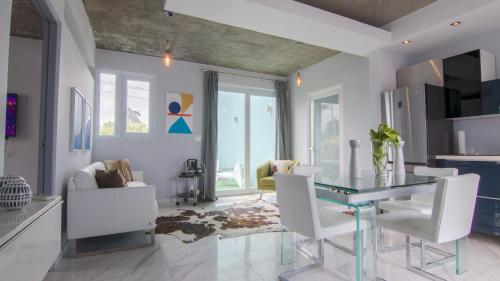 een woonkamer met een glazen tafel en witte stoelen bij Breeze Point at Ocean in San Juan