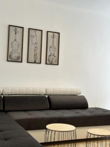 a living room with a black couch and three pictures on the wall at PANTELI APART HOUSE in Aheloy