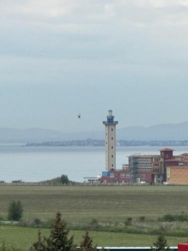 a building with a tower in the middle of a field at PANTELI APART HOUSE in Aheloy