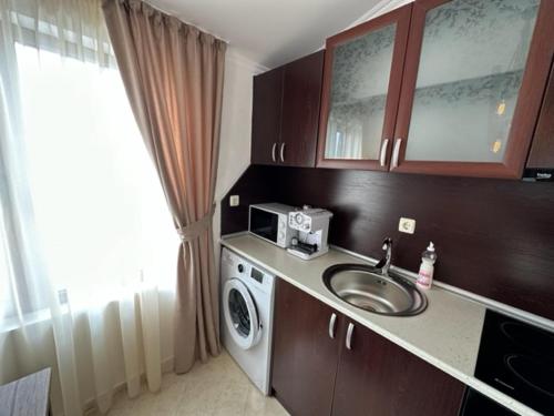 a bathroom with a sink and a washing machine at PANTELI APART HOUSE in Aheloy