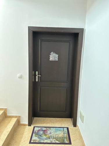 a black door with a mat in front of it at PANTELI APART HOUSE in Aheloy