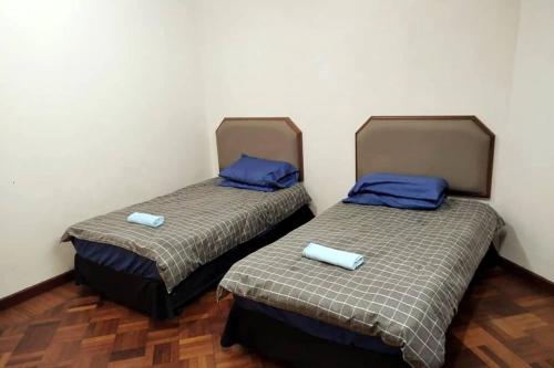 two beds sitting next to each other in a room at BC Homestay @ Equatorial Hill Apartment in Brinchang