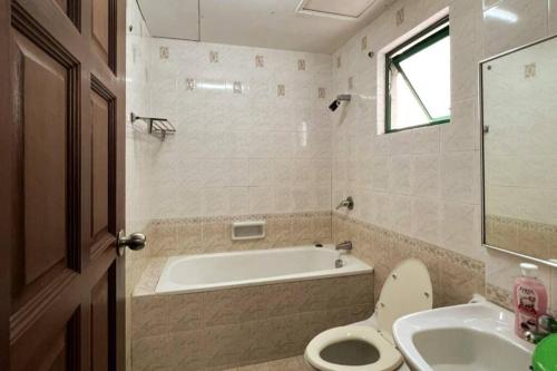 a bathroom with a tub and a toilet and a sink at BC Homestay @ Equatorial Hill Apartment in Brinchang