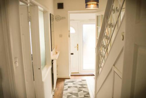 a hallway with a staircase and a door with a rug at Luxury House in Colnbrook near Windsor & Heathrow in Colnbrook