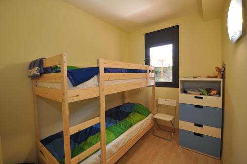 a bedroom with two bunk beds and a window at Pretty garden apartment next to a charming beach in Lloret de Mar