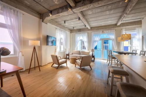 a living room with chairs and a table and some windows at Downtown Dreamstay, Classic 2BR Suites in Willemstad