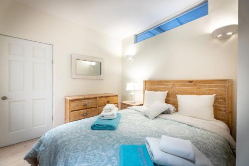 a bedroom with a large bed with a blue blanket at Downtown Dreamstay, Classic 2BR Suites in Willemstad