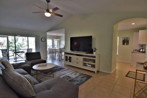 a living room with a couch and a flat screen tv at Florinda 3bdr/2bth 2car garage with New Pool in Sarasota