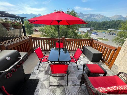 ファーニーにあるRiverside Condos by Fernie Central Reservationsのテーブルと椅子と傘のあるパティオ