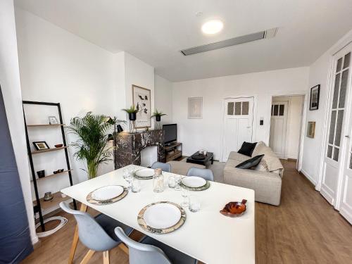 ein Wohnzimmer mit einem weißen Tisch und Stühlen in der Unterkunft Cosy Apartment Brussels - City Center in Brüssel