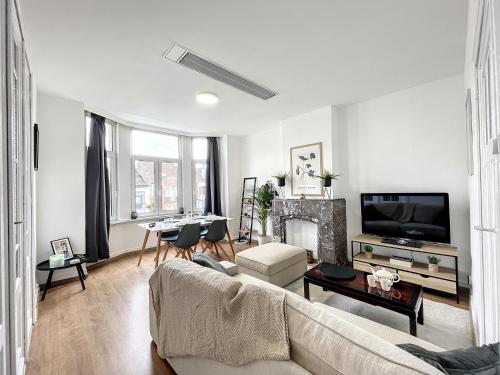 a living room with a couch and a tv at Hypercentre 4 in Brussels