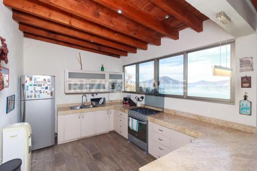 a kitchen with white cabinets and a large window at the best view in Valle de Bravo in Valle de Bravo