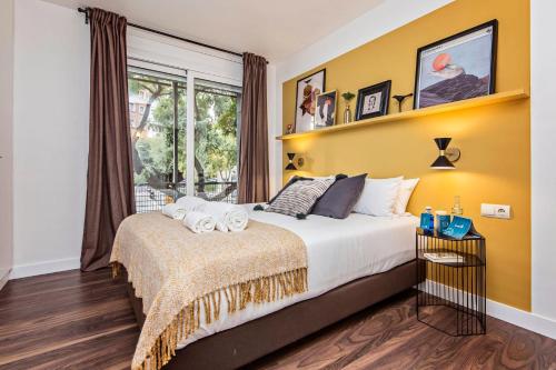 a bedroom with a large bed and a yellow wall at Sweet Inn Plaza Espana Fira in Barcelona