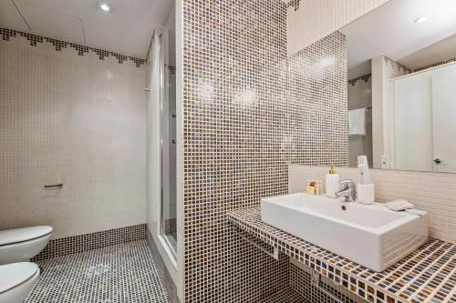 a bathroom with a sink and a shower and a toilet at Sweet Inn Plaza Espana Fira in Barcelona