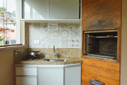 una cucina con lavandino e finestra di CONFORTO NA SERRA a Campos do Jordão