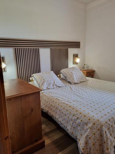 une chambre avec un lit et une commode en bois dans l'établissement LE GRAND TETRAS, à Samoëns