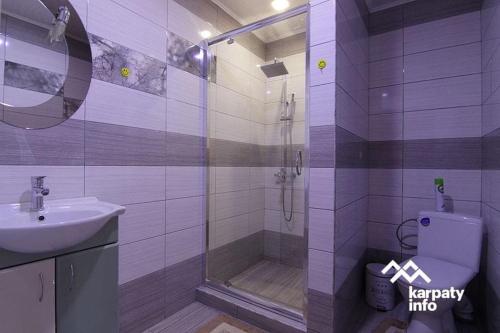y baño con ducha, aseo y lavamanos. en Карпатські Зорі, en Pilipets