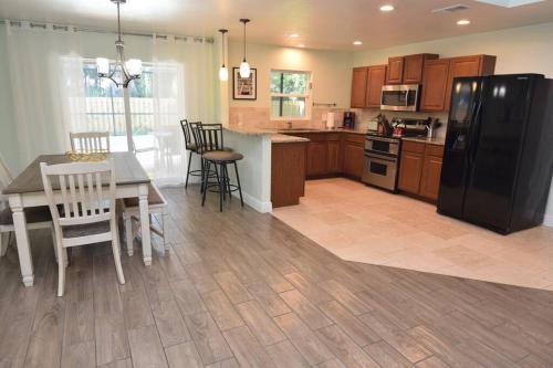 a kitchen with a table and a black refrigerator at New England 3bd 2bt Home Heated Pool Close to Siesta in Sarasota
