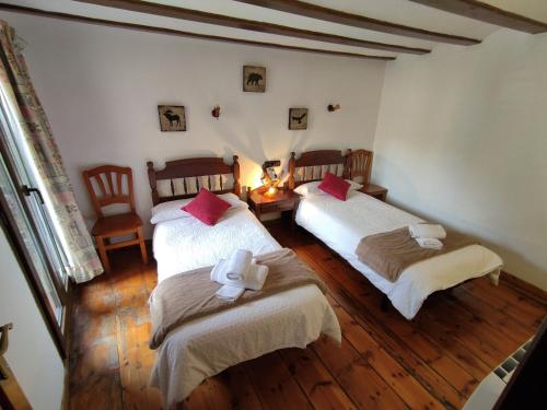 a room with two beds and a table and chairs at Casa de la Marmota in Eriste