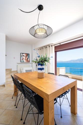 a dining room table with chairs and a potted plant on it at Artemis ΙnCreteble Cretan Resindences Collection in Sitia