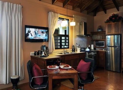 a kitchen with a table and chairs and a television at Villa Cayo in San Ignacio