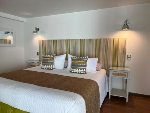 a bedroom with a large bed with pillows on it at Hotel Boutique La Perouse in Hanga Roa