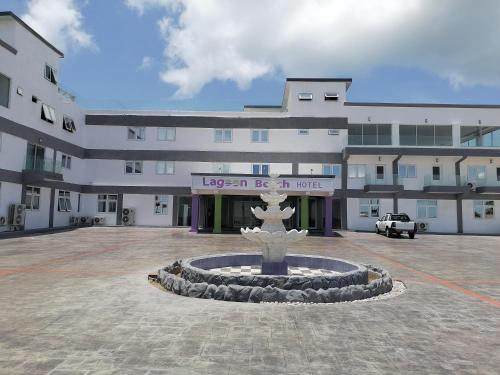 a building with a fountain in front of a building at Lagoonbeachhotel in Keta