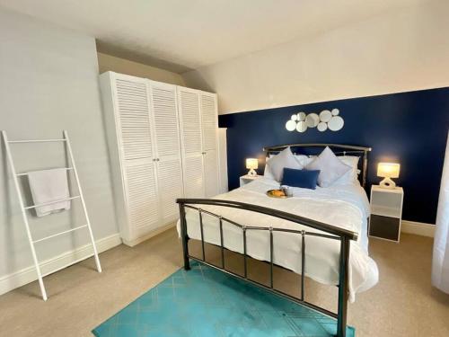 a bedroom with a bed with a blue wall at Serenity in Southsea in Portsmouth