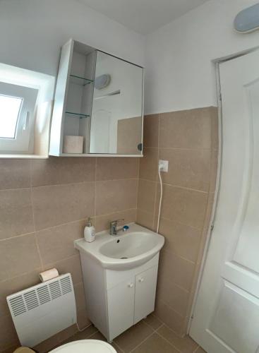 bagno con lavandino, servizi igienici e specchio di ROOR Top Nest 1 a Gheorgheni