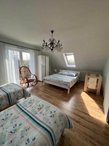 een slaapkamer met 2 bedden en een kroonluchter bij Dom nad Skawą - Zator 5km in Grodzisko