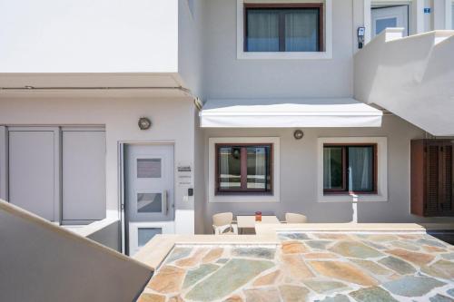 a room with a table and chairs and a building at Aretousa InCreteble Cretan Residences Collection in Sitia