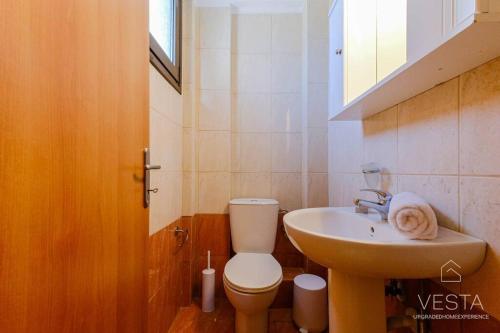 a small bathroom with a toilet and a sink at Heliophilia 3-bdrm Maisonette in Nea Fokea in Nea Fokea