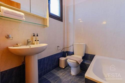 a bathroom with a sink and a toilet and a tub at Heliophilia 3-bdrm Maisonette in Nea Fokea in Nea Fokea