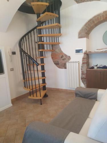 escalera de caracol en una sala de estar con sofá en Il Borgo della Leti en Bergamo