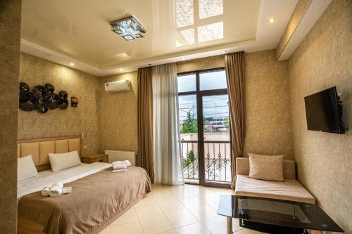 a bedroom with two beds and a tv and a window at Tbilisi Sea Hotel in Tbilisi City