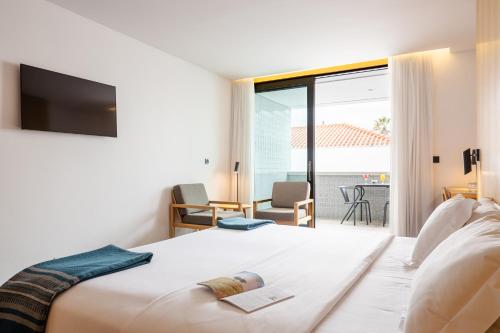 a hotel room with a bed and a balcony at Evora Olive Hotel in Évora
