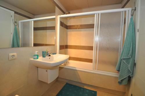 een badkamer met een wastafel en een douche bij Pretty garden apartment next to a charming beach in Lloret de Mar