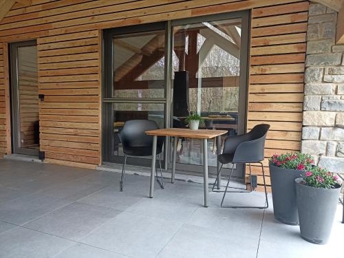 a patio with a table and chairs and a building at Toit & Moi. in Stoumont