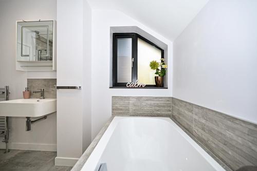 a white bathroom with a sink and a mirror at Stunning Detached House in Bassett in Southampton
