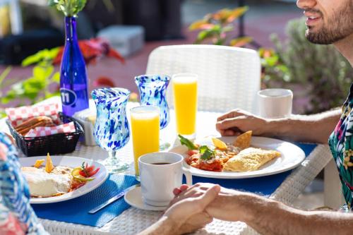 a group of people sitting at a table eating breakfast at Blue Chairs Beachfront Resort Puerto Vallarta - Adults Only in Puerto Vallarta