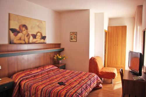 ein Hotelzimmer mit einem Bett und einem TV in der Unterkunft Hotel Los Angeles in Assisi