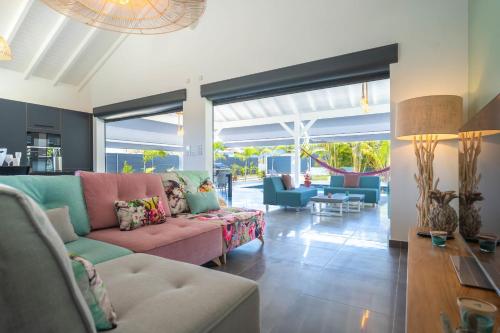 ein Wohnzimmer mit einer Couch und einigen Stühlen in der Unterkunft Villa Faustine in Saint-François