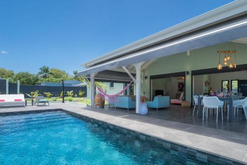 eine Villa mit Swimmingpool und einem Haus in der Unterkunft Villa Faustine in Saint-François