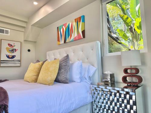 um quarto com uma cama branca com almofadas e uma janela em Elegant Retreat with Views Close to SF and Wine Regions em San Rafael